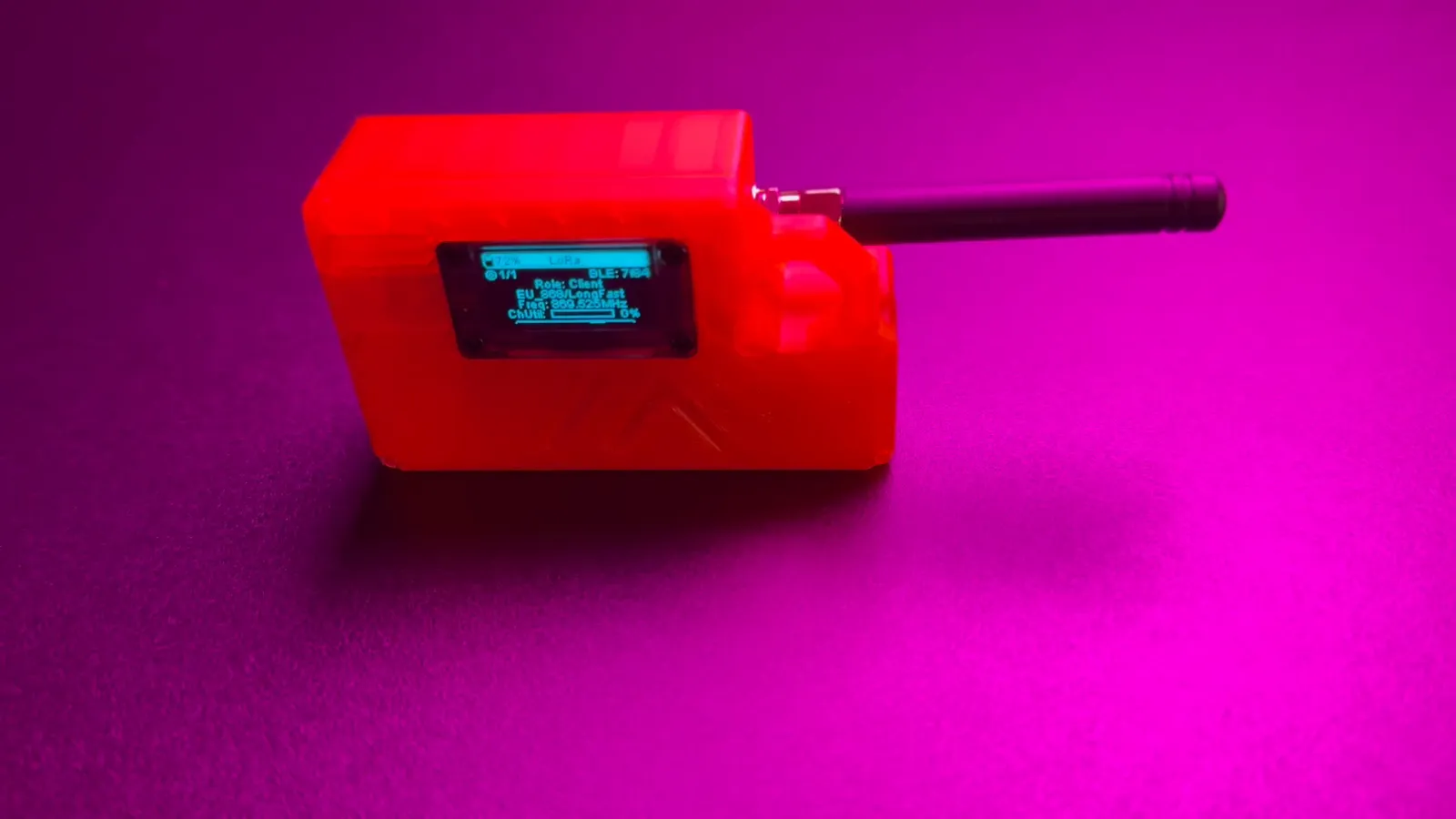 Selbstgebauter MeshCore-Client im orangefarbenen 3D-Druck-Gehäuse mit Antenne und OLED-Display